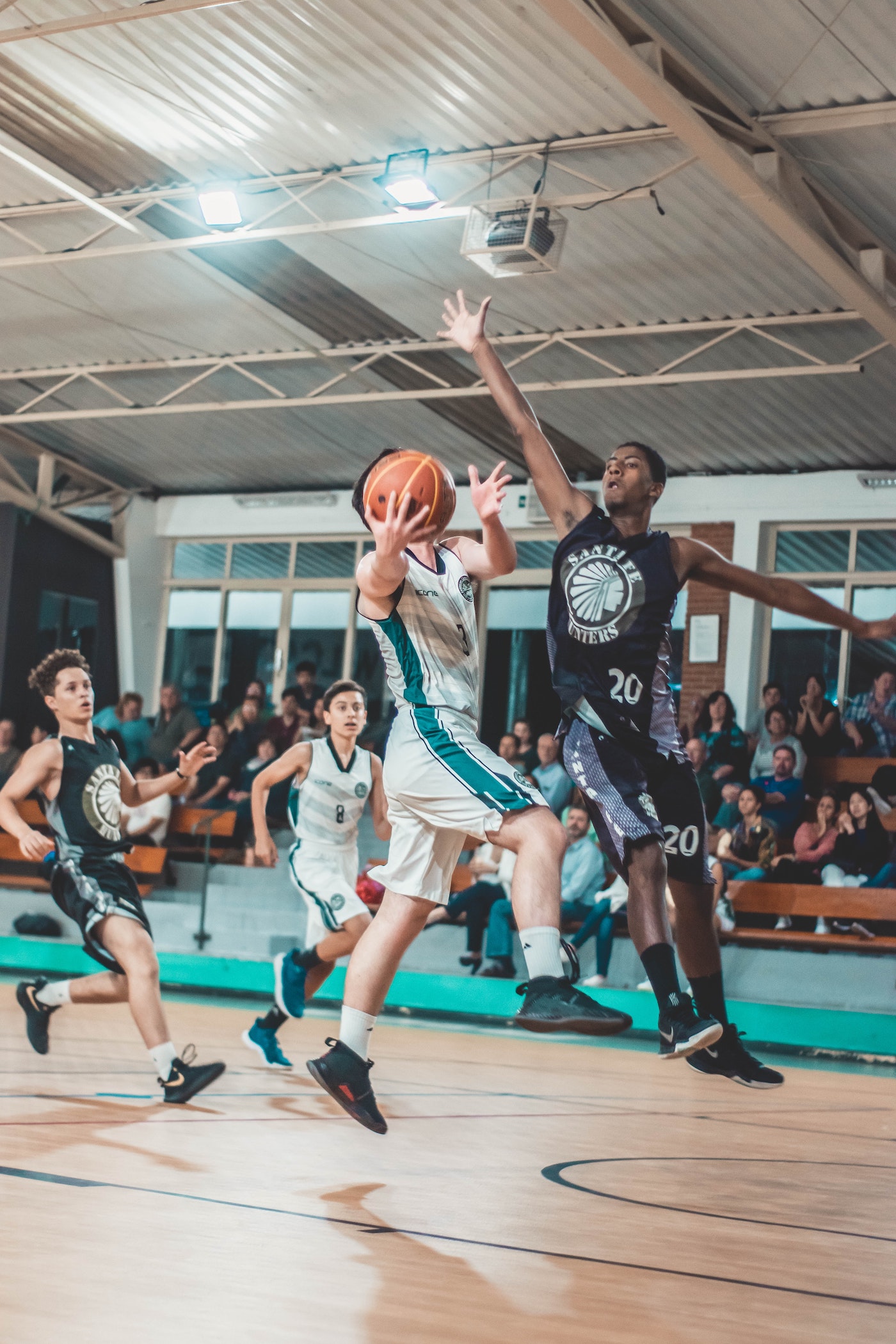 two players competing for the basket with one jumping to block